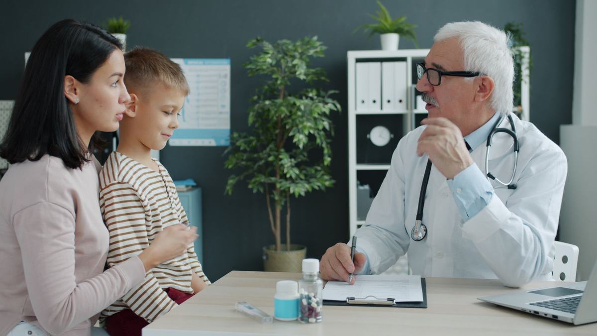 A doctor talks with a mother and her young son